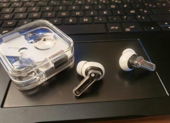 écouteurs sans fil Nothing Ear 2 et leur étui-chargeur sur un ordinateur portable
